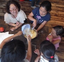 小さい子どもがお姉さんたちの様子を真剣にみています